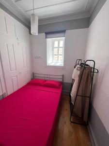 1 dormitorio con 2 camas rojas y ventana en Casa Flamingo, en Figueira da Foz