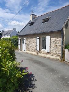 a stone house with white doors and a road at penty vero in Plobannalec-Lesconil