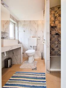 a bathroom with a white toilet and a rug at Eleonora in Banjole