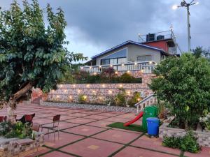 a backyard with a red brick wall and a playground at Hilltop Resort and Agro Tourism Wai, Near Panchgani in Wai