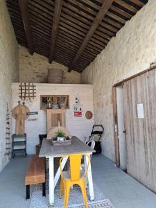 un patio con mesa y 2 sillas amarillas en Maison dépaysante au calme Soyaux Angoulême, en Soyaux