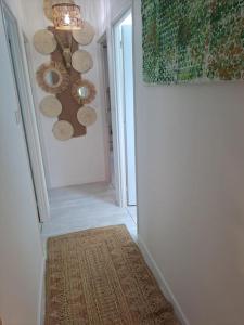 a hallway with a chandelier and a rug at Maison dépaysante au calme Soyaux Angoulême in Soyaux