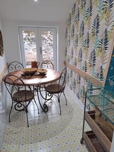 comedor con mesa, sillas y ventana en Maison dépaysante au calme Soyaux Angoulême, en Soyaux