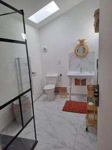 Baño blanco con aseo y lavamanos en Maison dépaysante au calme Soyaux Angoulême, en Soyaux