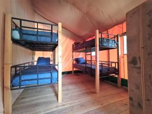 a room with two bunk beds in a tent at Le Lodge de la Chouette in Quarré-les-Tombes