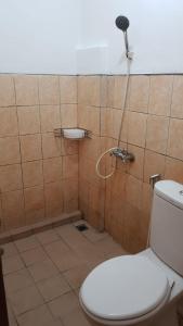 uma casa de banho com um WC e um chuveiro em Hotel Cemara Gading em Bubulak 3