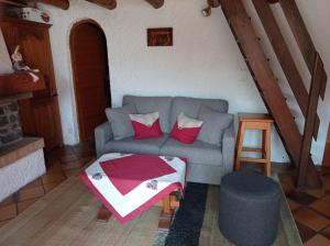 ein Wohnzimmer mit einem Sofa und einem Tisch in der Unterkunft Chalet Chez Nous in Domancy