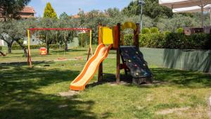 a playground with a slide in a park at Alexandros Hotel Apartments in Vourvourou