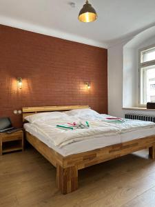 a bedroom with a wooden bed with a brick wall at VAPARTMANY in Plumlov