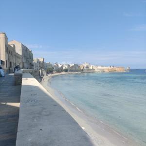 a view of a beach with buildings and the ocean at Carlo's rooms in Trapani