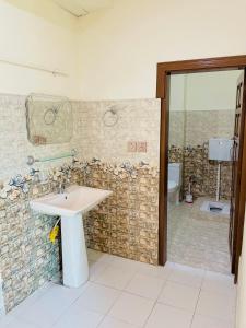 W łazience znajduje się umywalka i prysznic. w obiekcie Kashmir Heaven Guest House w mieście Muzaffarabad