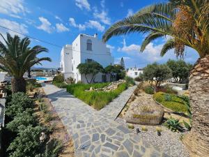 einen Gehweg mit Palmen und einem weißen Gebäude in der Unterkunft Sunlight Naxos in Naxos Chora