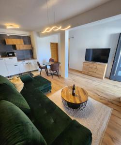 a living room with a green couch and a table at Apartman Lidija in Starigrad