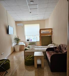 a room with two beds and a couch at Coin Apartments & Poshtel in Chernivtsi