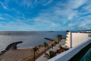 a view of the beach and the ocean from a balcony at Apartamentos Llobet Ibiza in Ibiza Town