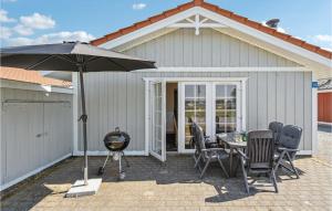 patio con ombrellone, sedie e griglia di 4 Bedroom Stunning Home In Grsten a Gråsten