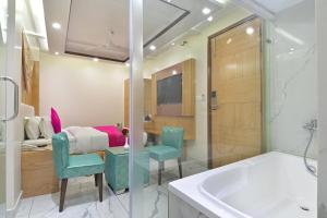 a bathroom with a sink and a tub and a bedroom at Aman International-A New Unit of Aman Continental in New Delhi