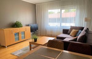 a living room with a couch and a tv at Kuressaare Holiday Apartments in Kuressaare