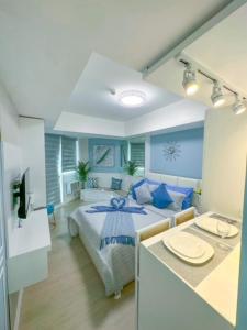 a bedroom with a bed with blue pillows at LA CASA ALEYKA AZURE NORTH PAMPANGA BALI Tower 518 in San Fernando