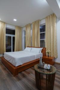 a bedroom with a bed and a table and windows at Richfields in Ooty
