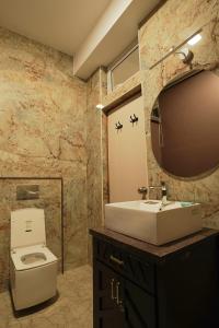 La salle de bains est pourvue d'un lavabo, de toilettes et d'un miroir. dans l'établissement Richfields, à Ooty