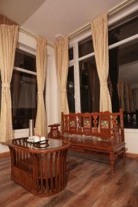 a living room with two benches and a table at Richfields in Ooty