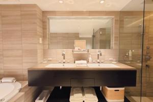 a bathroom with two sinks and a mirror and a toilet at A10 hotel azabu ten in Tokyo