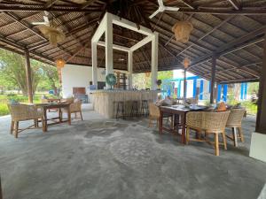 a restaurant with tables and chairs and a bar at Blue EmOcean Dive Eco lodge in Moyo Island