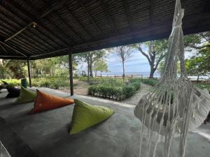 a hanging hammock with colorful pillows on a patio at Blue EmOcean resort in Moyo Island