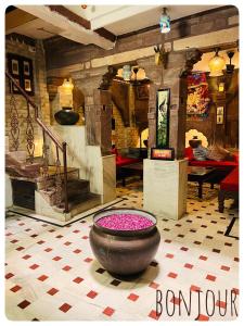 a room with a large pot with pink flowers in it at Raj Mandir Boutique Home Stay in Jodhpur