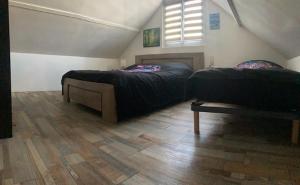 1 Schlafzimmer mit 2 Betten und Holzboden in der Unterkunft Maison calme 