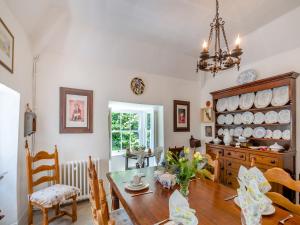 a dining room with a table and a chandelier at Ty Het in Llanfairpwllgwyngyll