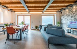 ein Wohnzimmer mit einem Tisch, Stühlen und einer Ziegelwand in der Unterkunft La cà del Bisun in Colico