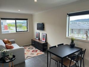 a living room with a table and a couch and a television at Adorable 1 bedroom Unit in Coombs in Weston Creek