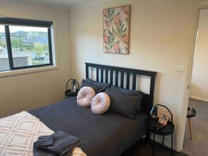 a bedroom with a bed with two pillows on it at Adorable 1 bedroom Unit in Coombs in Weston Creek