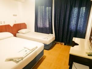 um quarto de hotel com duas camas e uma janela em Paşa Restaurant & Pansiyon em Kemer
