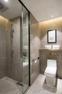 a bathroom with a toilet and a glass shower at Morning Hotel, Changsha Provincial Government Metro Station in Changsha