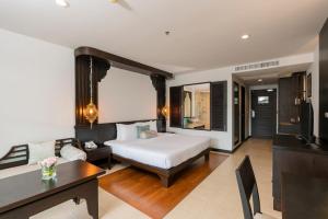 1 dormitorio con 1 cama y sala de estar en Ravindra Beach Resort & Spa - SHA Extra Plus en Na Jomtien