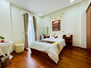 a bedroom with a bed and a desk and a table at NEW PALACE HOTEL in Quang Ngai