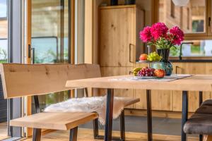 a table with a vase of flowers and fruit on it at Kroner Chalets in Zwiesel