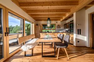 een keuken en eetkamer met een houten tafel en stoelen bij Kroner Chalets in Zwiesel