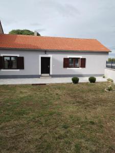 a white house with a red roof and a yard at Holiday Home Nena in Drniš