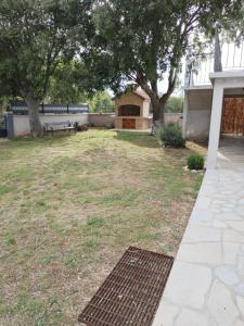 a backyard with a bench and trees and grass at Holiday Home Nena in Drniš