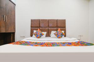 a bedroom with a large bed with colorful pillows at FabHotel S Pride in Indore