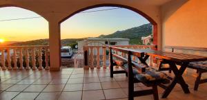 a table and chairs on a balcony with the sunset at Apartments Stefan Cesarica in Cesarica