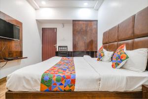 um quarto com uma cama grande e uma televisão em FabHotel S Pride em Indore