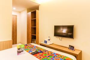 Pokój z łóżkiem i telewizorem z płaskim ekranem w obiekcie FabExpress Ascot International Andheri East w Bombaju