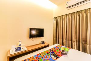 a hotel room with a bed and a tv at FabExpress Ascot International Andheri East in Mumbai