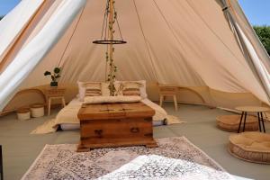 Zelt mit einem Bett und einem Tisch in der Unterkunft Rescorla Retreats- Poldark in Mevagissey