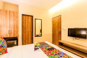 FabExpress Ascot International Andheri East في مومباي: غرفة بسرير وتلفزيون بشاشة مسطحة